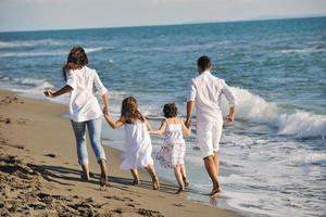 gelukkig jong familie hebben pret Aan strand foto