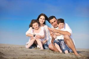 gelukkig jong familie hebben pret Aan strand foto