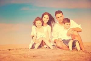 gelukkig jong familie hebben pret Aan strand foto