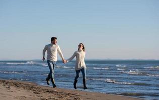 liefhebbend jong paar Aan een strand Bij herfst zonnig dag foto