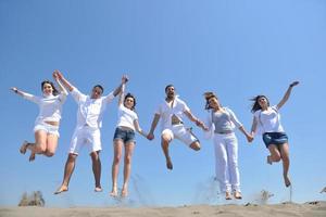 gelukkig mensen groep hebben pret en rennen Aan strand foto