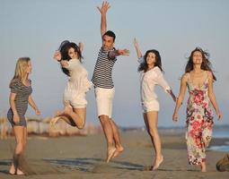 gelukkig jong mensen groep hebben pret Aan strand foto