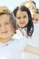 gelukkig kind groep spelen op strand foto