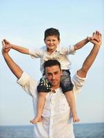 gelukkig jong familie hebben pret Aan strand foto