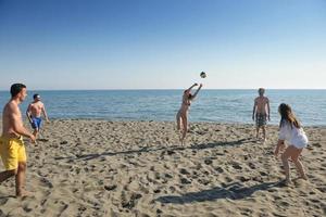 jong mensen groep hebben pret en Speel strand volleybal foto