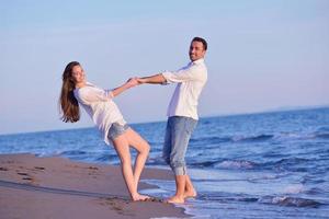 jong paar Aan strand hebben pret foto