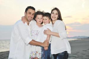 gelukkig jong familie hebben pret Aan strand foto