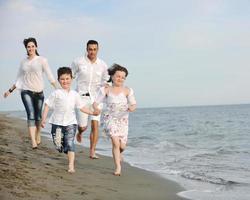 gelukkig jong familie hebben pret Aan strand foto