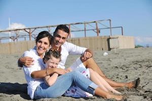 gelukkig jong familie hebben pret Aan strand foto