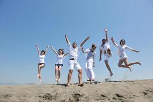 gelukkig mensen groep hebben pret en rennen Aan strand foto