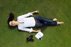 jonge vrouw die een boek in het park leest foto