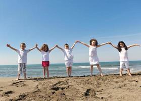 gelukkig kind groep spelen op strand foto