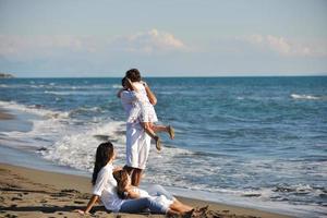 gelukkig jong familie hebben pret Aan strand foto