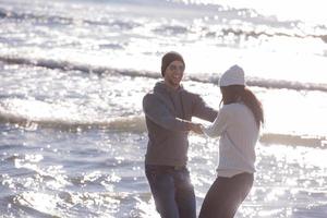 liefhebbend jong paar Aan een strand Bij herfst zonnig dag foto