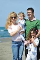 gelukkig jong familie hebben pret Aan strand foto