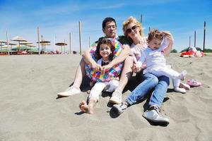 gelukkig jong familie hebben pret Aan strand foto