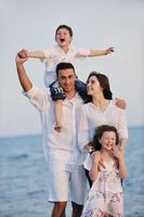 gelukkig jong familie hebben pret Aan strand foto