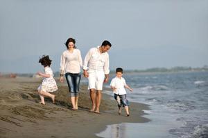 gelukkig jong familie hebben pret Aan strand foto