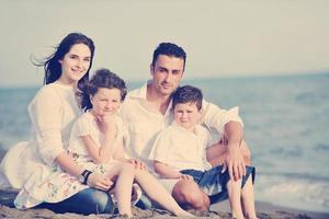 gelukkig jong familie hebben pret Aan strand foto