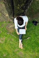 jonge vrouw die een boek in het park leest foto