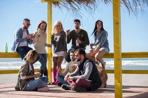 groep van vrienden hebben pret Aan herfst dag Bij strand foto