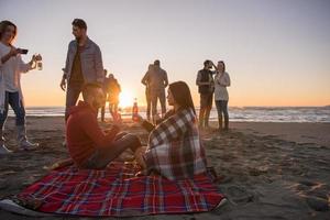 paar genieten van met vrienden Bij zonsondergang Aan de strand foto