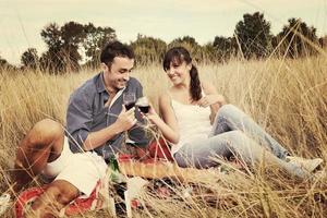 gelukkig paar genieten van platteland picknick in lang gras foto