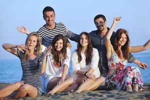 gelukkig jong mensen groep hebben pret Aan strand foto