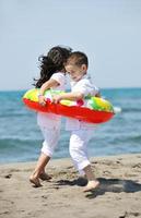 gelukkig jong mensen groep hebben pret Aan strand foto