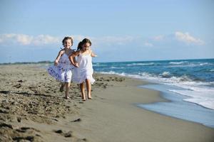 schattig weinig meisjes rennen Aan strand foto