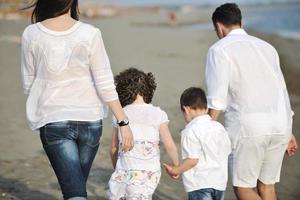 gelukkig jong familie hebben pret Aan strand foto