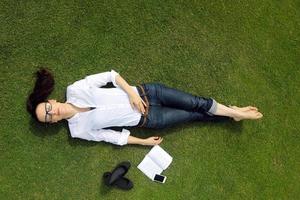 jonge vrouw die een boek in het park leest foto