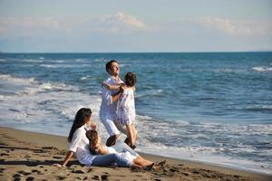 gelukkig jong familie hebben pret Aan strand foto