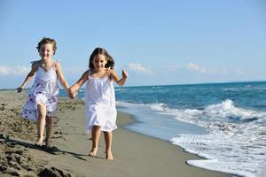 schattig weinig meisjes rennen Aan strand foto