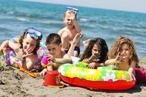 kind groep hebben pret en Speel met strand speelgoed foto