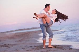 jong paar Aan strand hebben pret foto