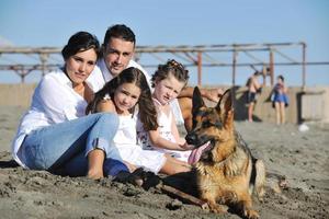 gelukkig familie spelen met hond Aan strand foto