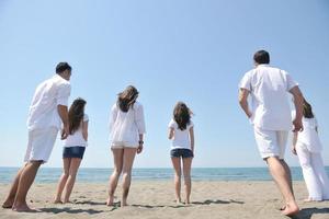 gelukkig mensen groep hebben pret en rennen Aan strand foto