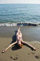 jong vrouw kom tot rust Aan strand foto