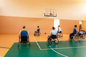 gehandicapt oorlog veteranen gemengd ras en leeftijd basketbal teams in rolstoelen spelen een opleiding bij elkaar passen in een sport- Sportschool hal. gehandicapten mensen revalidatie en inclusie concept foto