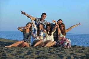 gelukkig jong mensen groep hebben pret Aan strand foto