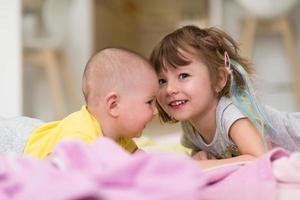 weinig zus en haar baby broer spelen Bij huis foto