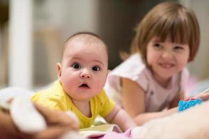 weinig zus en haar baby broer spelen Bij huis foto