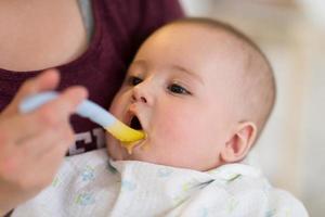 moeder met lepel voeden weinig baby foto