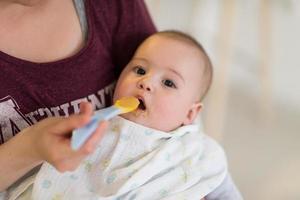 moeder met lepel voeden weinig baby foto