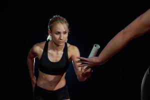 atletisch hardlopers voorbijgaan stok in relais ras foto