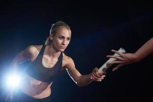 atletisch hardlopers voorbijgaan stok in relais ras foto