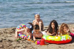 kind groep hebben pret en Speel met strand speelgoed foto