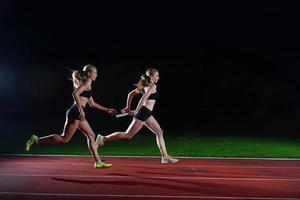 atletisch hardlopers voorbijgaan stok in relais ras foto