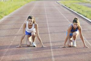 twee meisjes rennen Aan atletisch ras bijhouden foto